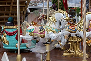 Festive carousel with beautiful bright horses. City amusement park, Christmas entertainment