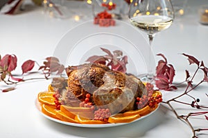 Festive celebration roasted chicken with orange slices and rowan berries for Thanksgiving or Christmas dinner.