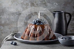 Festive Chocolate marble cake baked in a Pudding baking mold, with chocolate glaze, blueberries. Dark grey background. Blown out