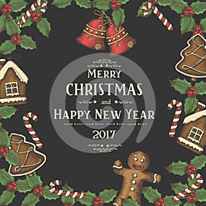 Festive Christmas background with holly leaves, cakes and candies on black. Greeting inscription Happy New Year and Merry