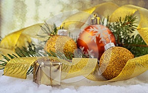 Festive Christmas balls, small box with present, gold ribbon and fir branches