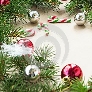 Festive christmas border with red and silver balls on fir branches and snowflakes on rustic beige background