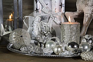 Festive christmas decoration in silver with burning candles.