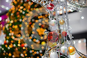 festive Christmas eve decorated space construction object in shopping mall with balls and garland colorful lights bokeh effects