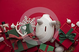 Festive Christmas financial savings concept. White piggy bank money box with presents and decorations