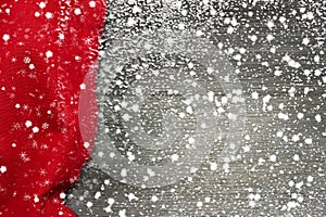 Festive Christmas holiday winter background with bright red tablecloth covered sparkling snowflakes on rustic wooden table