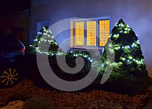 Festive Christmas lighting of the house. Ceremonial Christmas lights for the house in winter. Illuminated Christmas tree