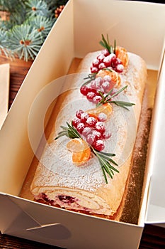 Festive Christmas meringue roll with cherries packed for present