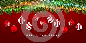 Festive Christmas or New Year Background. Christmas fir-tree branches with light garland and xmas red balls. Holiday`s Background