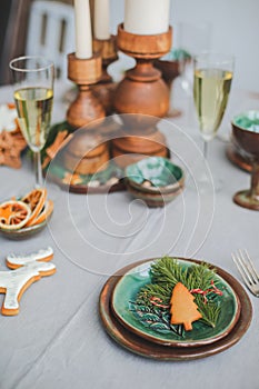 Festive Christmas and New Year table setting in scandinavian style with rustic handmade details in natural and white