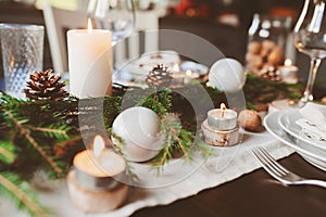 Festive Christmas and New Year table setting in scandinavian style with rustic handmade details in natural and white tones