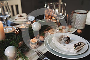 Festive Christmas and New Year table setting in scandinavian style with rustic handmade details in natural and white tones