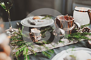 Festive Christmas and New Year table setting in scandinavian style with rustic handmade details in natural and white tones