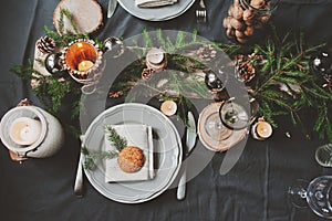 Festive Christmas and New Year table setting in scandinavian style with rustic handmade details in natural and white tones