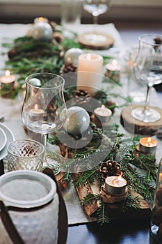 Festive Christmas and New Year table setting in scandinavian style with rustic handmade details in natural and white tones