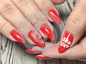 Festive Christmas-themed manicure in red shades with snowflakes