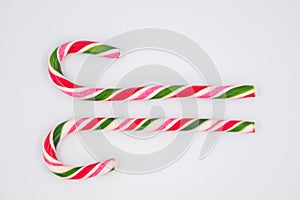 Festive Christmas treat. Flat lay of striped red candy cane isolated on white background. Copy space