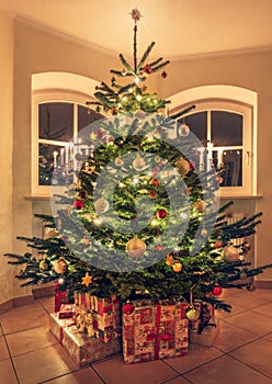 Festive Christmas tree with garland lights, gifts and decoration