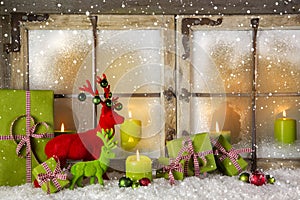 Festive christmas window decoration in green and red with presents and candles.