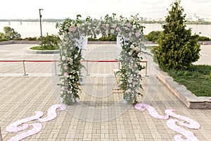 A festive chuppah decorated with fresh beautiful flowers for an outdoor wedding ceremony