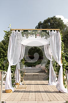 A festive chuppah decorated with fresh beautiful flowers for an outdoor wedding ceremony