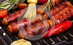 Festive cocktail sausages wrapped in crispy smoked bacon commonly known as `Pigs in Blankets` in black pan