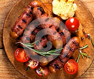 Festive cocktail sausages wrapped in crispy smoked bacon commonly known as `Pigs in Blankets` on wooden background