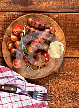 Festive cocktail sausages wrapped in crispy smoked bacon commonly known as `Pigs in Blankets` on wooden background