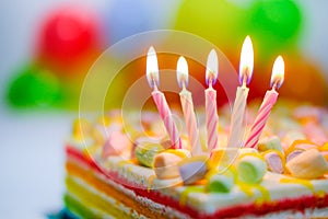 Festive colorful birthday card with five burning candles on rainbow cake and colorful balloons on background. Space for