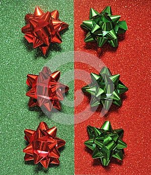 Festive colorful bows on sparkling glitter paper texture. Holiday background.