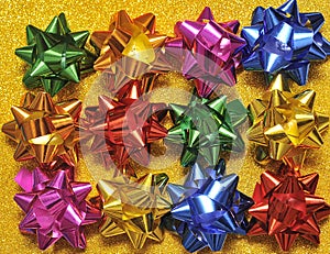 Festive colorful bows on sparkling glitter paper texture. Holiday background.