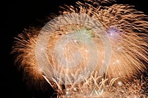 Festive colorful fireworks on night sky background. Celebratory holiday