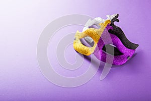 A festive, colorful group of mardi gras or carnivale mask on a purple background. Venetian masks