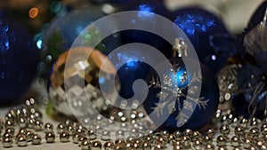 Festive composition with blue and silver christmas tree toys. Concept. Blinking blurred garland and beautiful small and