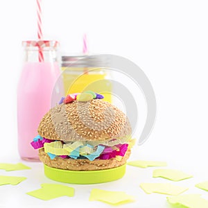 Festive composition drinks snacks holiday hamburger cookie tinsel confetti gift box cocktail saturated colors.