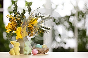 Festive composition with Easter eggs in decorative nest on table against window, space for text