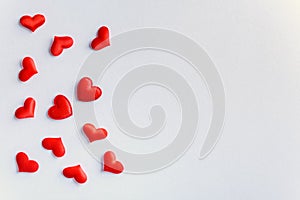 Festive composition from red hearts scattered on white background, valentines day concept, copy space