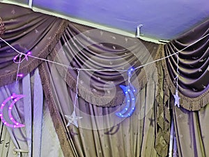 Festive decoration inside a flat for Ramadan fasting month for Muslims, led lights of stars and crescent moon as a celebration of