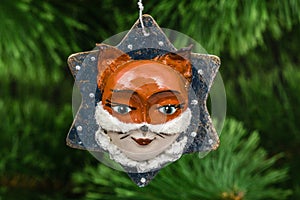 Festive decoration in the shape of a foxy mask, on a Christmas t