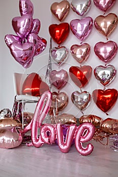 Festive decorations for Valentine's day, wedding or hen party. Love sign and heart shape balloons on white