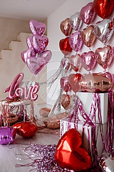 Festive decorations for Valentine's day, wedding or hen party. Love sign and heart shape balloons on white