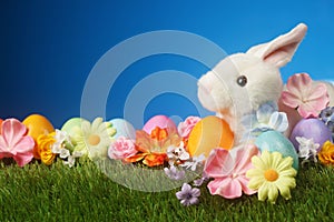 Festive Easter background with rabbit, flowers, and colorful egg