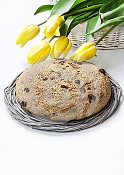 Festive easter bread and bouquet of beautiful yellow tulips