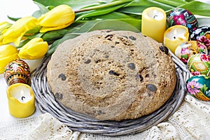 Festive easter bread and bouquet of beautiful yellow tulips