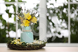 Festive Easter composition with flowers on table against window, space for text