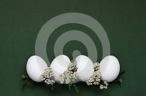 Festive Easter eggs with white small flowers on a green background.