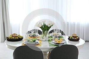 Festive Easter table setting with beautiful tulips and eggs indoors