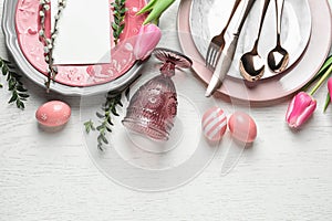 Festive Easter table setting with blank card on wooden background