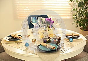 Festive Easter table setting with eggs in kitchen