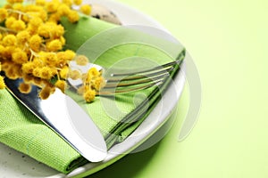 Festive Easter table setting with floral decor on green background, closeup